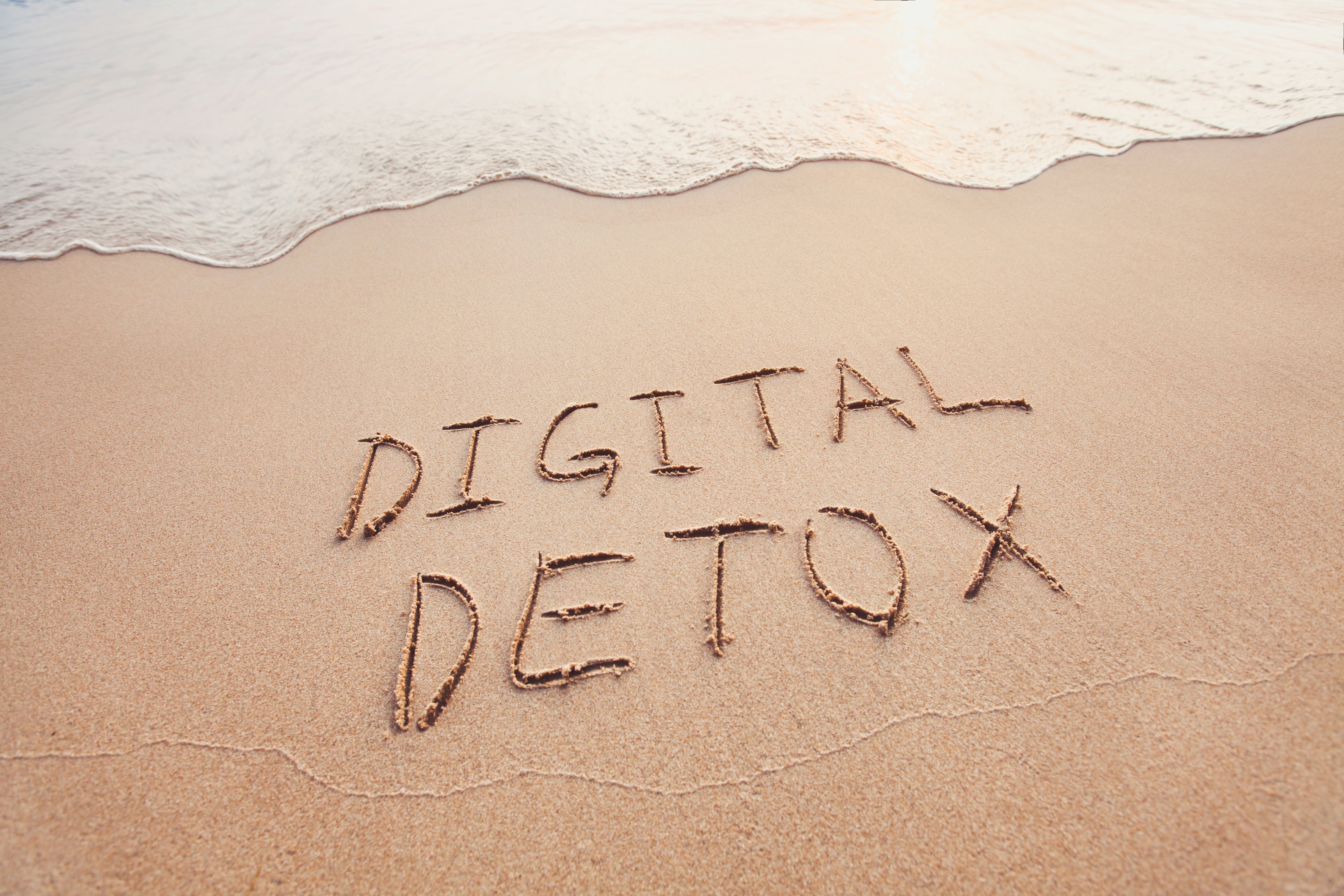 Digital detox written in the sand as the tide goes out.