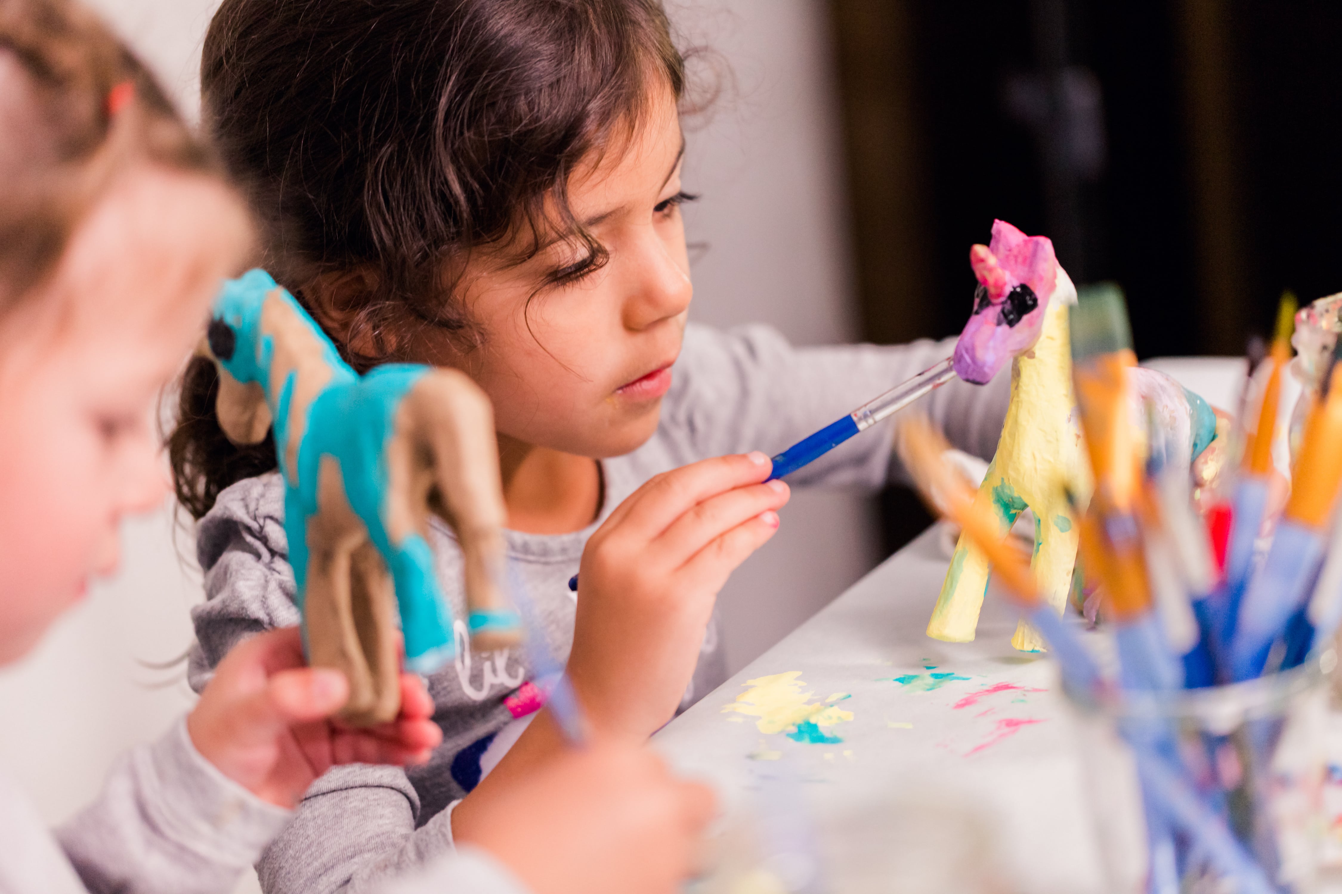 Two children working very hard while creating their own art and crafts masterpieces.