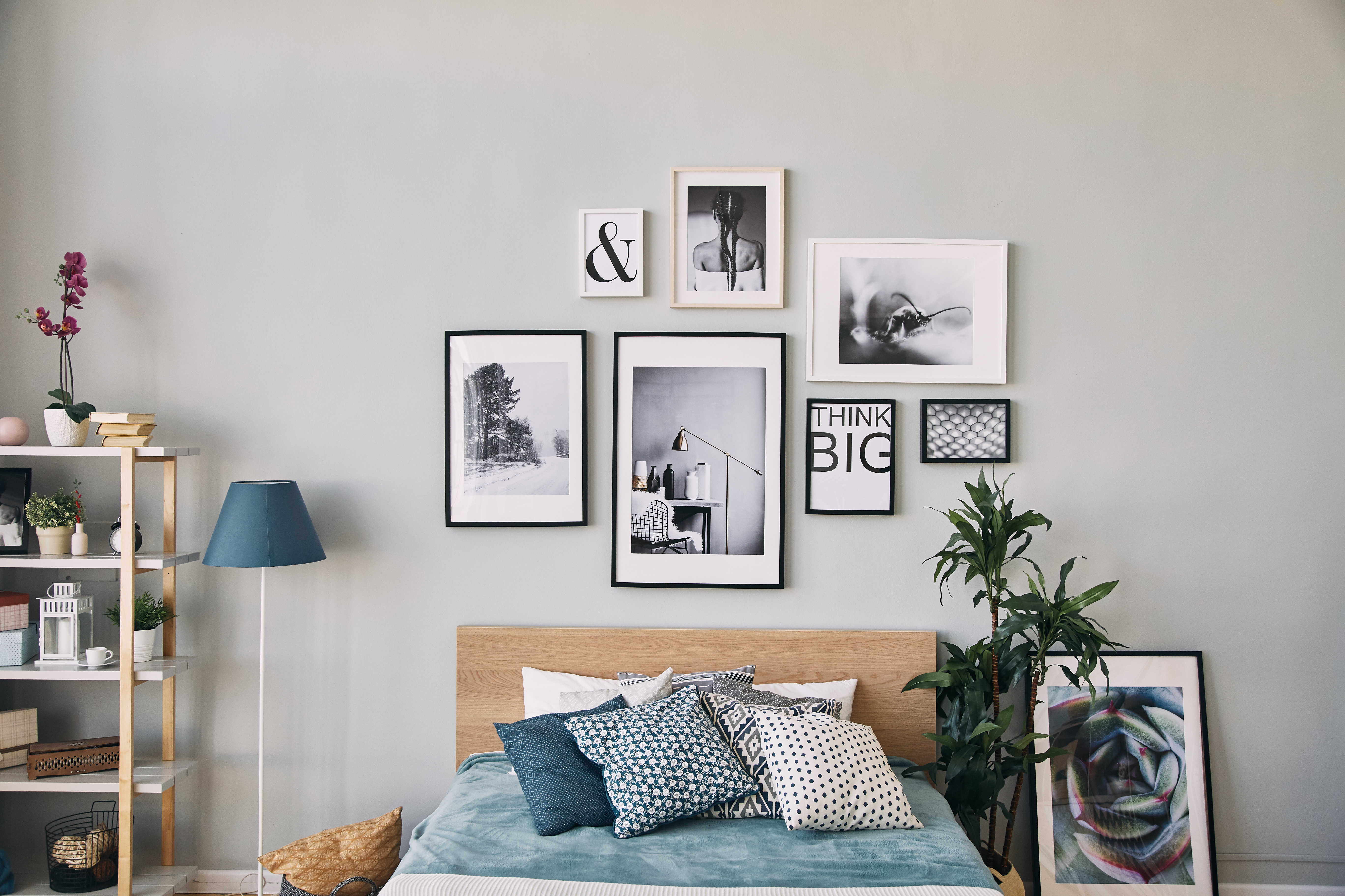 A guest bedroom featuring framed wall art hanging above the bed's headboard.