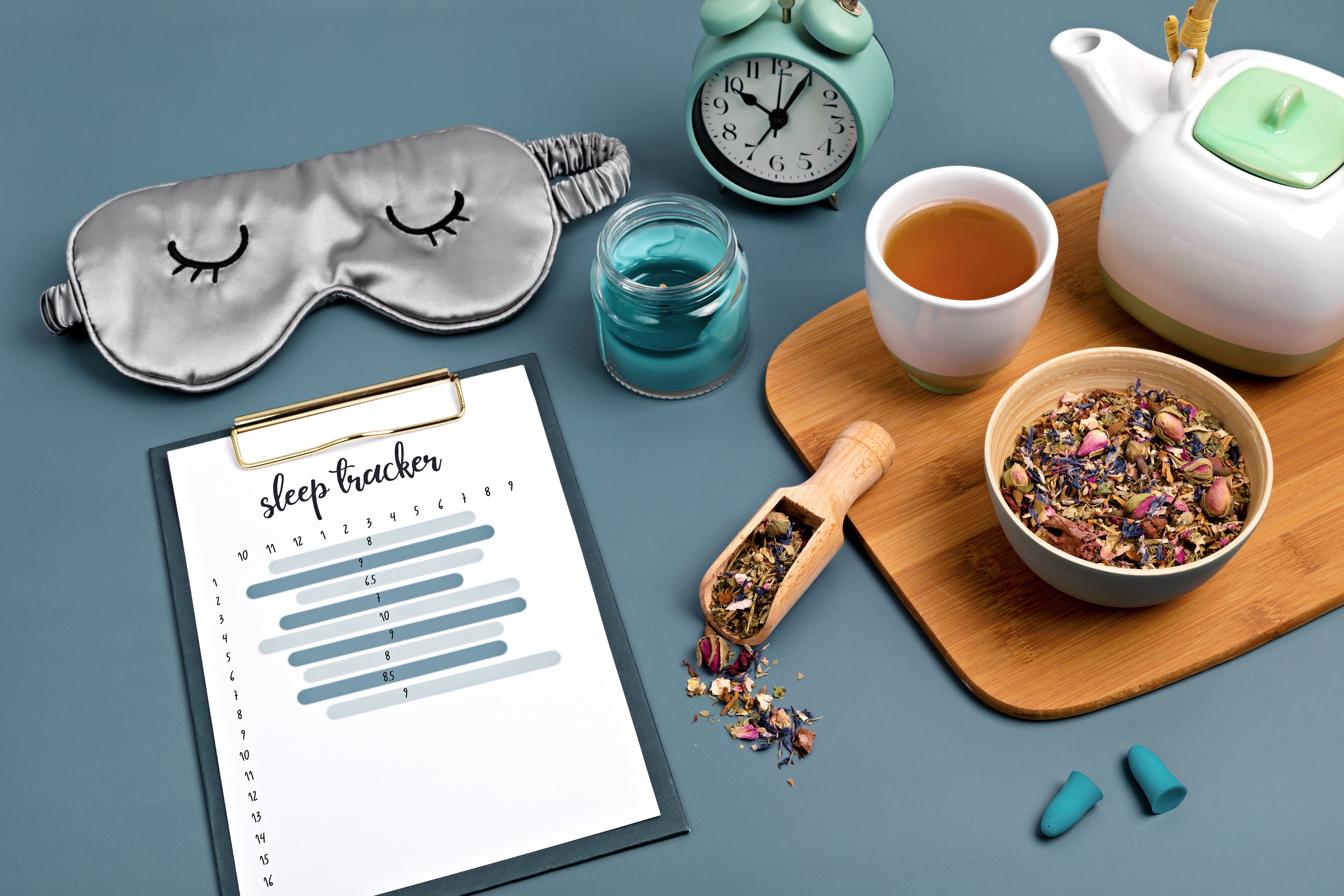 A collection of elements that can be worked into good sleep hygiene including herbal tea, and alarm clock, a sleep mask, and a sleep journal.