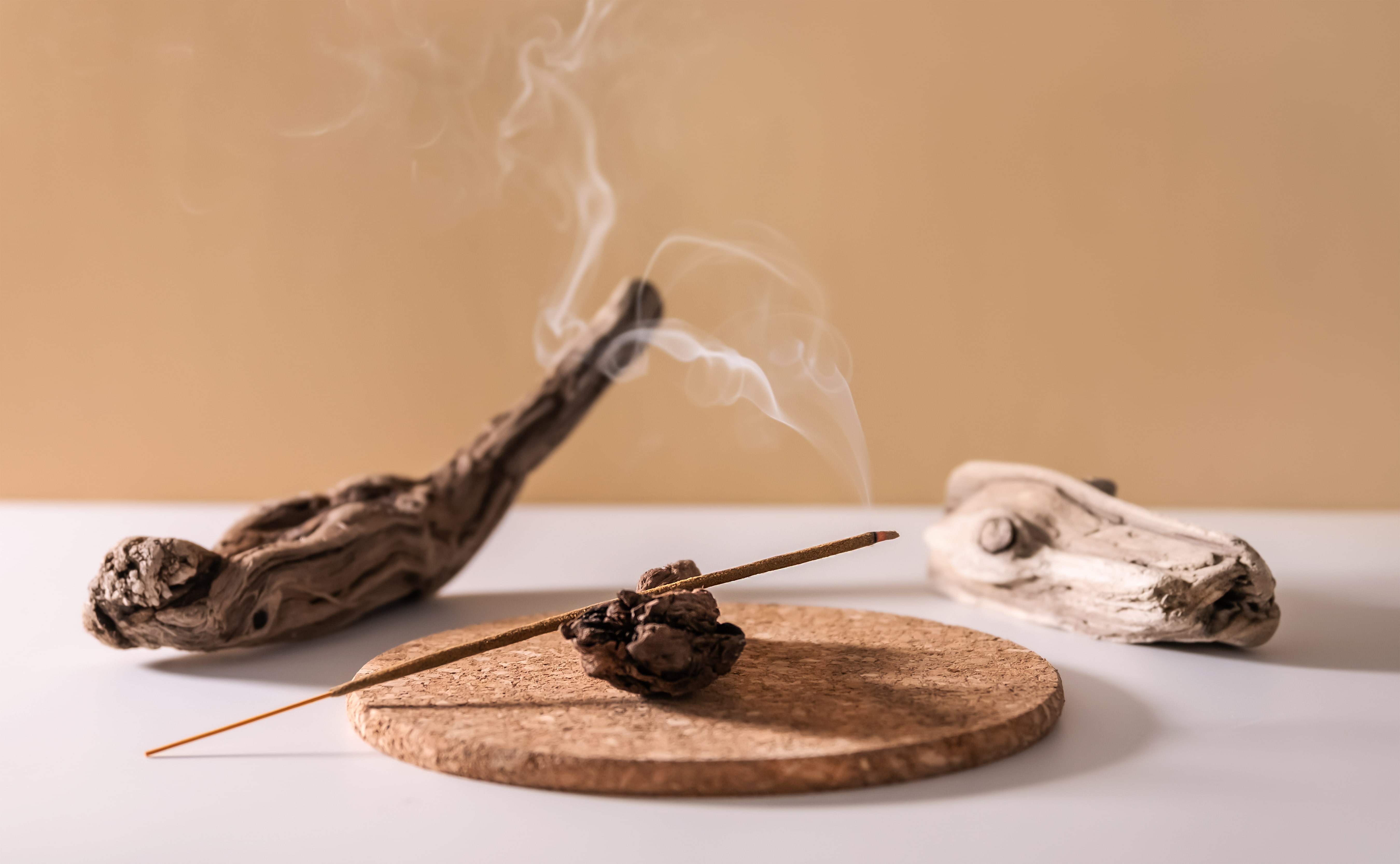 Incense burning beside some driftwood. 