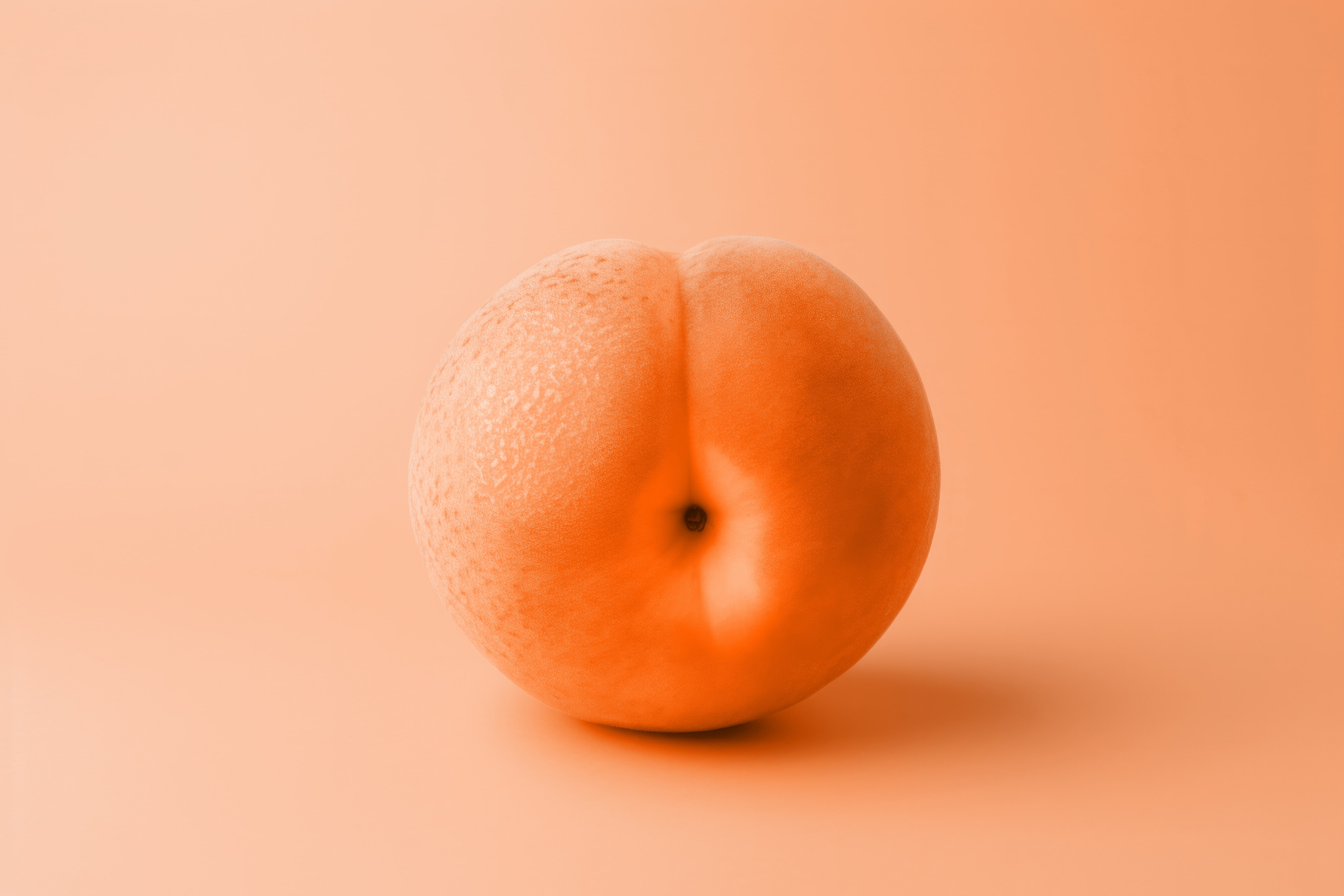 A peach on a peach fuzz coloured background